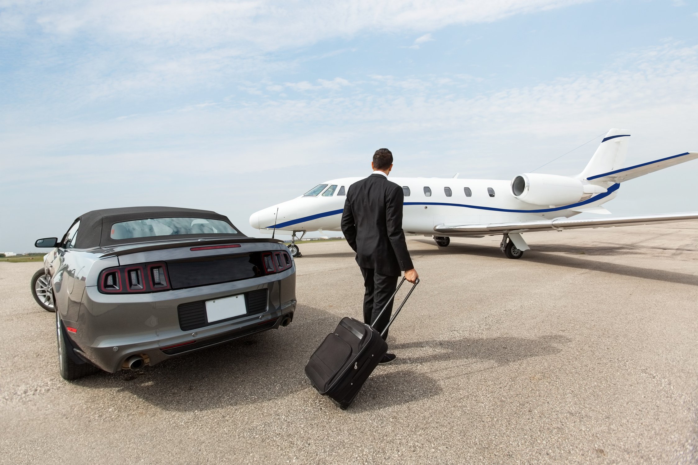 Businessman Standing by Car and Private Jet at Terminal